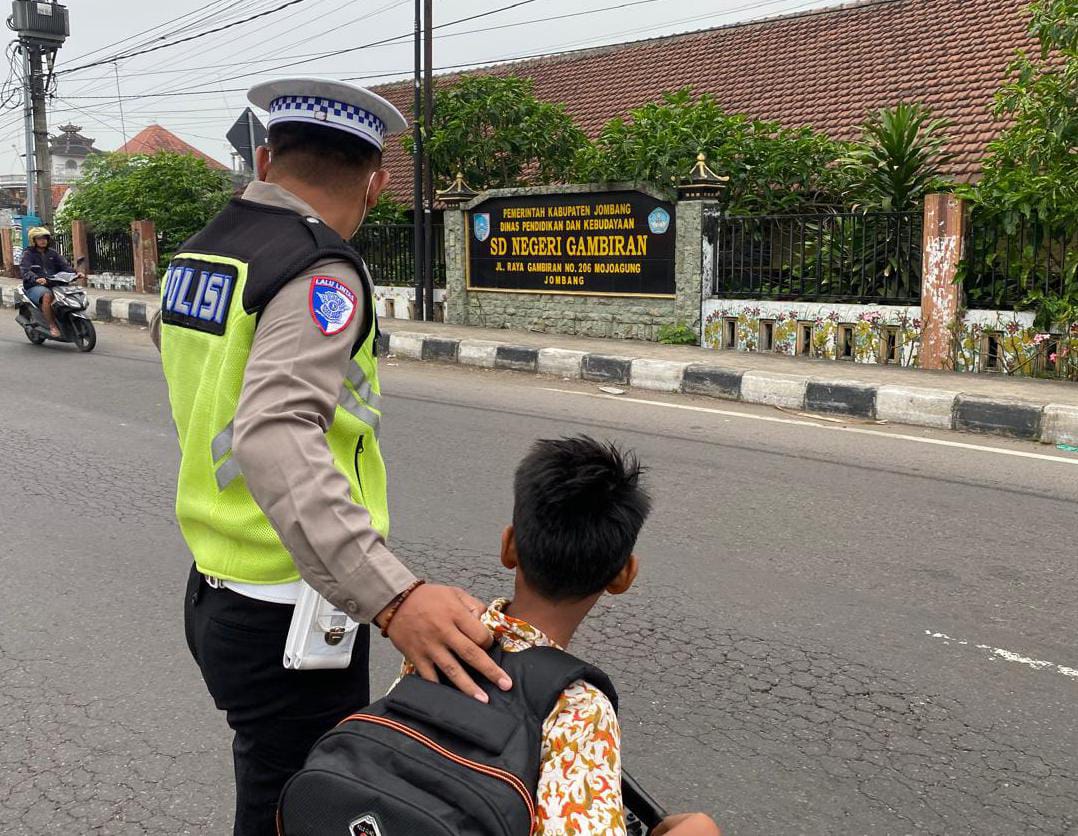Anggota Polsek Mojoagung Kring Pagi Dengan Membantu Menyebrangkan Siswa Sekolah